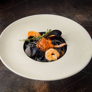 Deniz ürünleri, karides, kalamar, midye ve kırmızı havyar spagetti ile siyah makarna Nero. Güzel lezzetli yemek, restoran hizmet