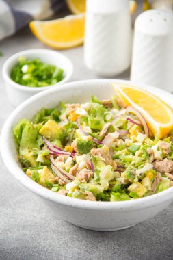 Ton balığı, avokado, soğan, yumurta ve limon ile salata. Bahar sağlıklı lezzetli öğle yemeği açık gri renkli