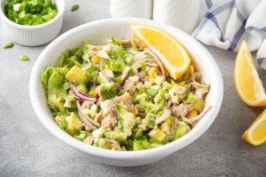 Ton balığı, avokado, soğan, yumurta ve limon ile salata. Bahar sağlıklı lezzetli öğle yemeği açık gri renkli