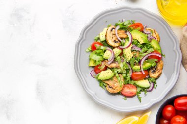 Taze bahar mantar, domates, soğan ve avokado salatası. Lezzetli vejetaryen yemek, sağlıklı gıda