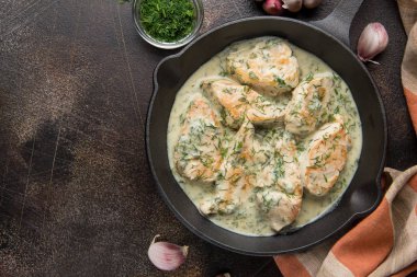 Tavuk fileto veya dereotu ve kalın sos ile koyu arka plan üzerinde siyah dökme demir Tavada sarımsak ile krem soslu hindi göğsü. Lezzetli ev yapımı yiyecek