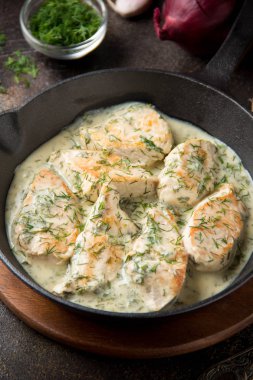 Tavuk fileto veya dereotu ve kalın sos ile koyu arka plan üzerinde siyah dökme demir Tavada sarımsak ile krem soslu hindi göğsü. Lezzetli ev yapımı yiyecek