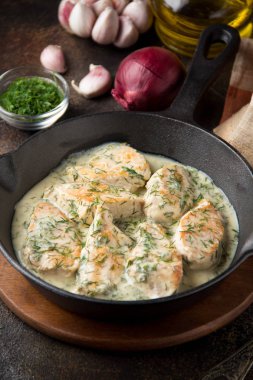 Tavuk fileto veya dereotu ve kalın sos ile koyu arka plan üzerinde siyah dökme demir Tavada sarımsak ile krem soslu hindi göğsü. Lezzetli ev yapımı yiyecek