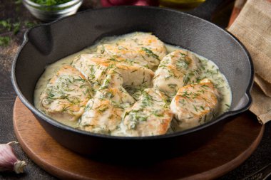 Tavuk fileto veya dereotu ve kalın sos ile koyu arka plan üzerinde siyah dökme demir Tavada sarımsak ile krem soslu hindi göğsü. Lezzetli ev yapımı yiyecek