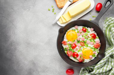 Jambon, domates ve yeşil soğan ile siyah tavada kızarmış yumurta. Kızarmış ekmek ve tereyağı ile lezzetli Breakfast. Klasik İngiliz öğle yemeği. Kopya alanı