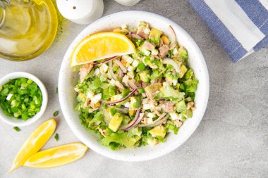 Ton balığı, avokado, soğan, yumurta ve limon ile salata. Bahar sağlıklı lezzetli öğle yemeği açık gri renkli