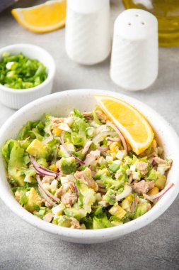 Ton balığı, avokado, soğan, yumurta ve limon ile salata. Bahar sağlıklı lezzetli öğle yemeği açık gri renkli