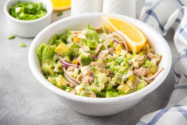 Ton balığı, avokado, soğan, yumurta ve limon ile salata. Bahar sağlıklı lezzetli öğle yemeği açık gri renkli