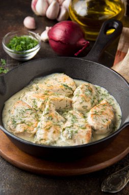 Tavuk fileto veya dereotu ve kalın sos ile koyu arka plan üzerinde siyah dökme demir Tavada sarımsak ile krem soslu hindi göğsü. Lezzetli ev yapımı yiyecek