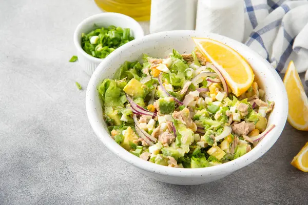 Ton balığı, avokado, soğan, yumurta ve limon ile salata. Bahar sağlıklı lezzetli öğle yemeği açık gri renkli