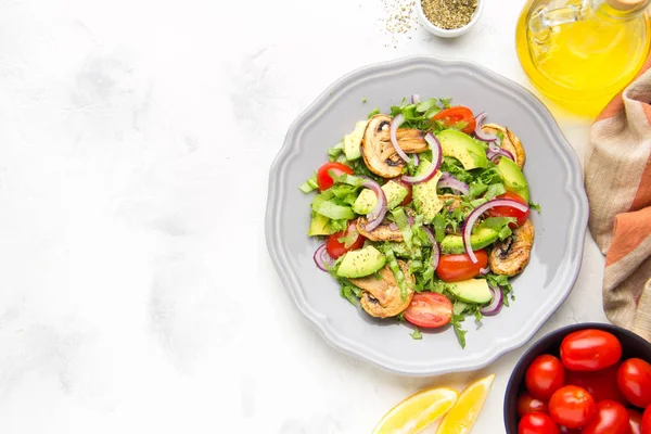 Taze bahar mantar, domates, soğan ve avokado salatası. Lezzetli vejetaryen yemek, sağlıklı gıda