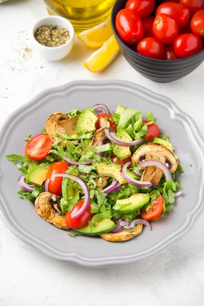 Taze bahar mantar, domates, soğan ve avokado salatası. Lezzetli vejetaryen yemek, sağlıklı gıda