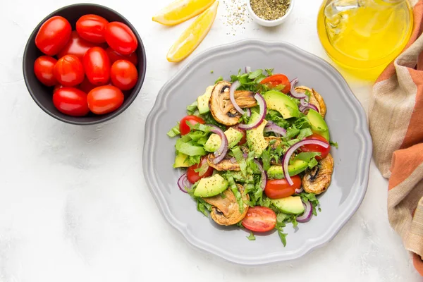 Taze bahar mantar, domates, soğan ve avokado salatası. Lezzetli vejetaryen yemek, sağlıklı gıda