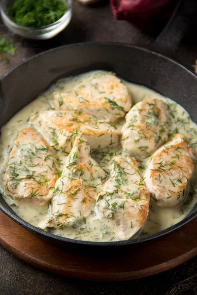 Tavuk fileto veya dereotu ve kalın sos ile koyu arka plan üzerinde siyah dökme demir Tavada sarımsak ile krem soslu hindi göğsü. Lezzetli ev yapımı yiyecek