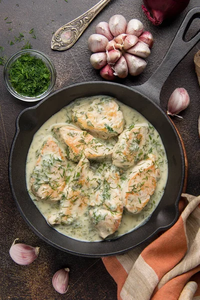 Tavuk fileto veya dereotu ve kalın sos ile koyu arka plan üzerinde siyah dökme demir Tavada sarımsak ile krem soslu hindi göğsü. Lezzetli ev yapımı yiyecek