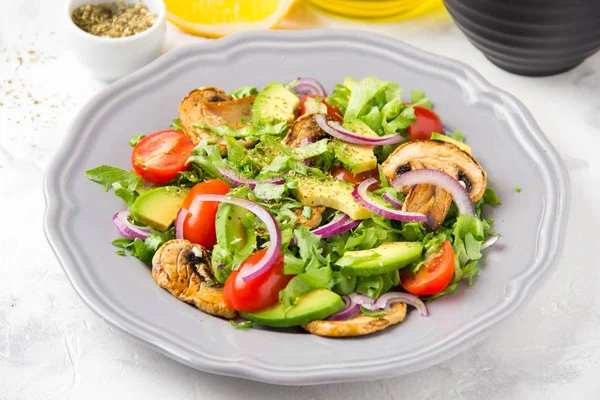 Taze bahar mantar, domates, soğan ve avokado salatası. Lezzetli vejetaryen yemek, sağlıklı gıda