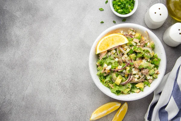 Ton balığı, avokado, soğan, yumurta ve limon ile salata. Bahar sağlıklı lezzetli öğle yemeği açık gri renkli