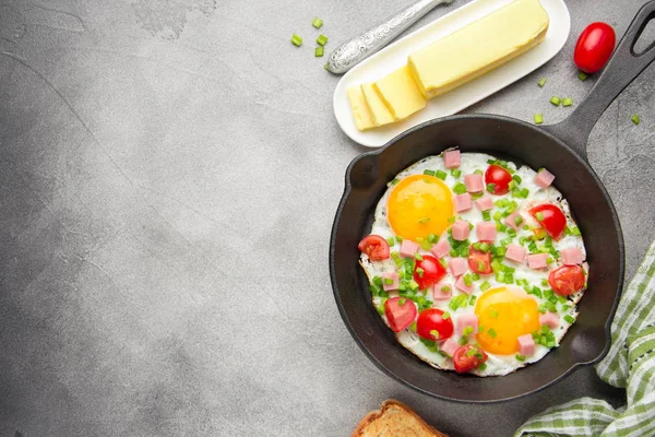 Jambon, domates ve yeşil soğan ile siyah tavada kızarmış yumurta. Kızarmış ekmek ve tereyağı ile lezzetli Breakfast. Klasik İngiliz öğle yemeği. Kopya alanı