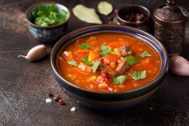 Et, tahıl ve sebze ile kalın domates çorbası. Geleneksel Doğu mutfağı, baharatlı güveç dana veya kuzu, pirinç ve baharatlar ile. Koyu arka plan üzerinde gıda