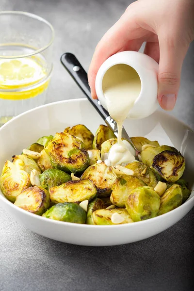 Brotes de Bruselas asados con cacahuetes y salsa blanca, deliciosos —  Fotos de Stock