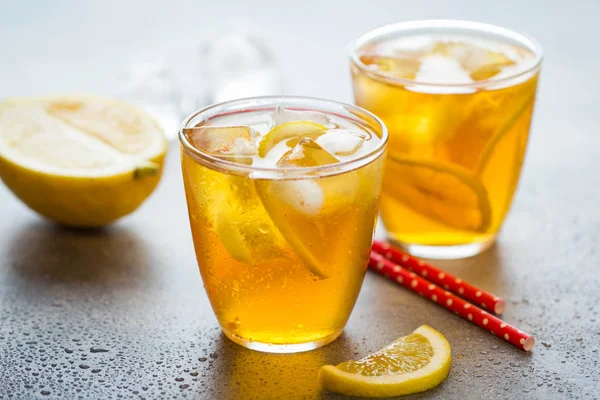 Tè freddo con limone e ghiaccio in un bicchiere con gocce, dolce fresco f — Foto Stock