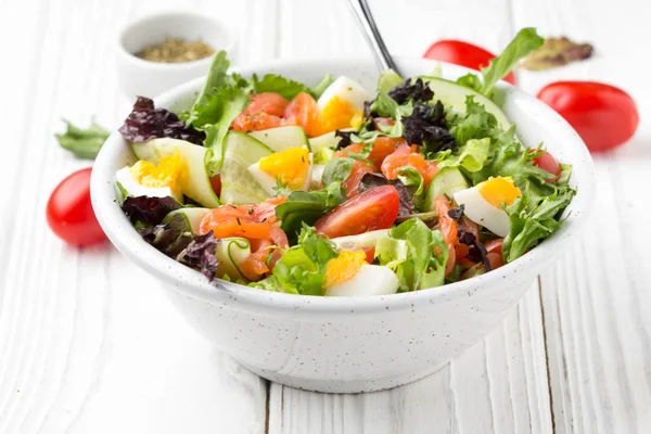 Salaatti lohen, munien ja vihannesten kanssa (kirsikkatomaatit, kurkku — kuvapankkivalokuva