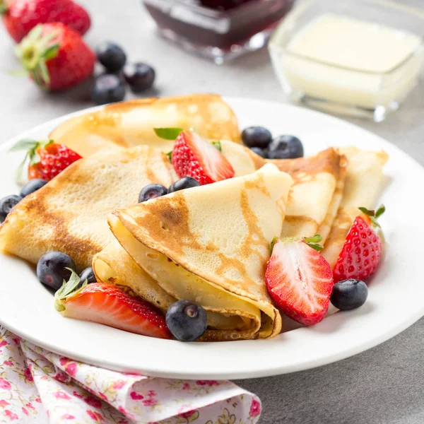 Panqueques finos con fresas y arándanos, mermelada, condensados — Foto de Stock