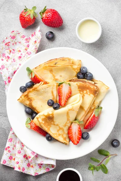 Panqueques finos con fresas y arándanos, mermelada, condensados — Foto de Stock