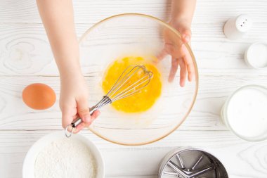 Çocuk küçük eller beat yumurta, panc için hazırlayın