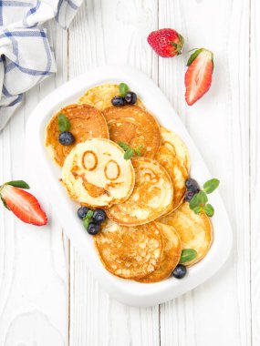 Krep gülümsüyor ile beyaz bir plaka üzerinde çilek ile