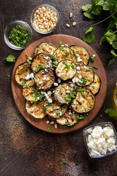 Fried eggplant with feta, pine nuts, fresh herbs (cilantro, pars — Stock Photo, Image