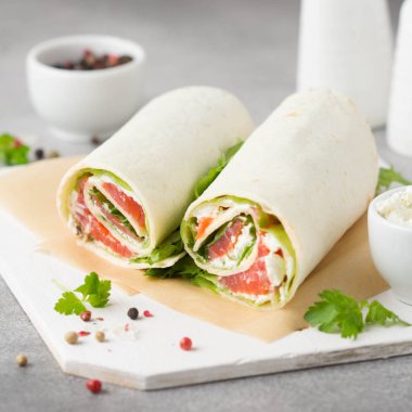 Somon, marul ve krem peyniri olan tortilla. Lezzetli snack 