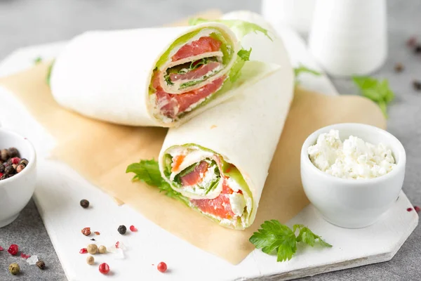 Tortilla com salmão, alface e creme de queijo. Delicioso lanche — Fotografia de Stock