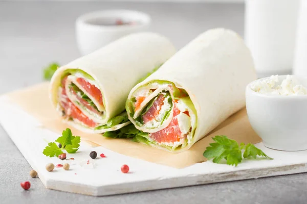 Tortilla com salmão, alface e creme de queijo. Delicioso lanche — Fotografia de Stock