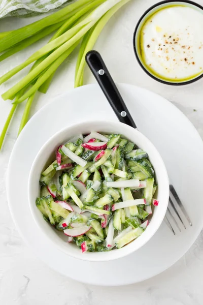 Салат с редиской, огурцом, зеленым луком и сметаным соусом , — стоковое фото