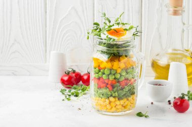 Yumuşak haşlanmış yumurta, sıvı sarısı ile kavanozda taze salata. Mısır, gree