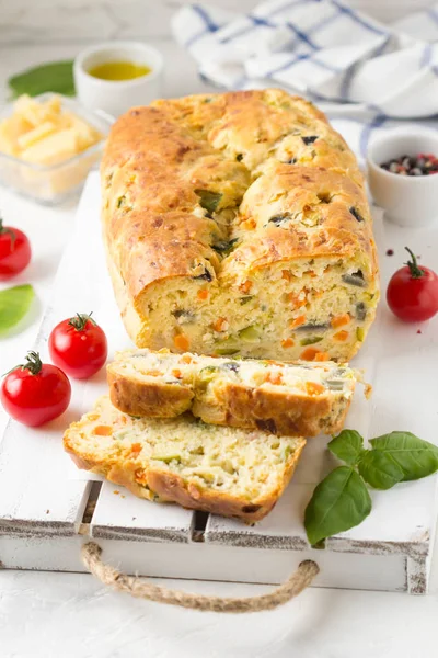 Snack cake with vegetables (zucchini, eggplant, carrot, tomato) and cheese. A tasty lunch, food, healthy baking