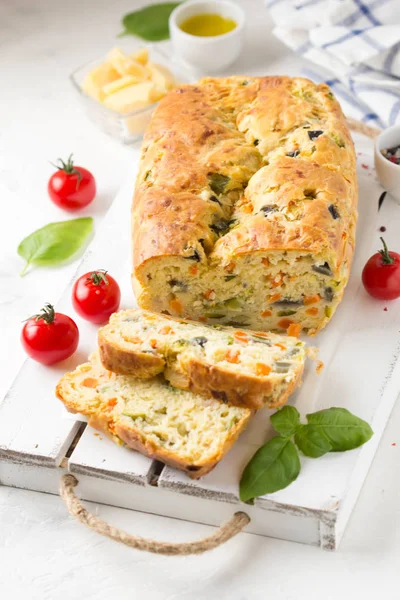Snack cake with vegetables (zucchini, eggplant, carrot, tomato) and cheese. A tasty lunch, food, healthy baking