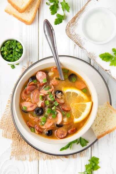Traditional Russian soup Solyanka with beef, chicken, sausage, l