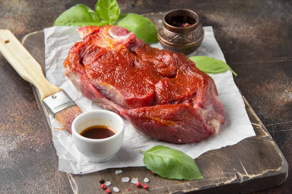 Raw beef on bone, cooking steak with spices, barbecue marinade, — Stock Photo, Image