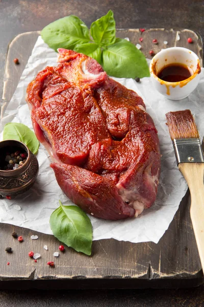 Raw beef on bone, cooking steak with spices, barbecue marinade, — Stock Photo, Image