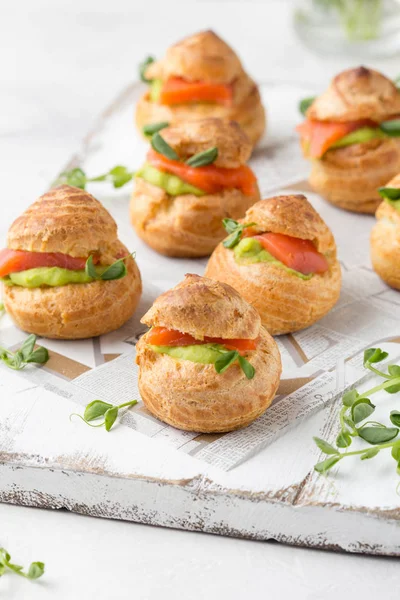 Snack pasteles profiteroles con crema de guisantes verdes y salmón rojo fis — Foto de Stock