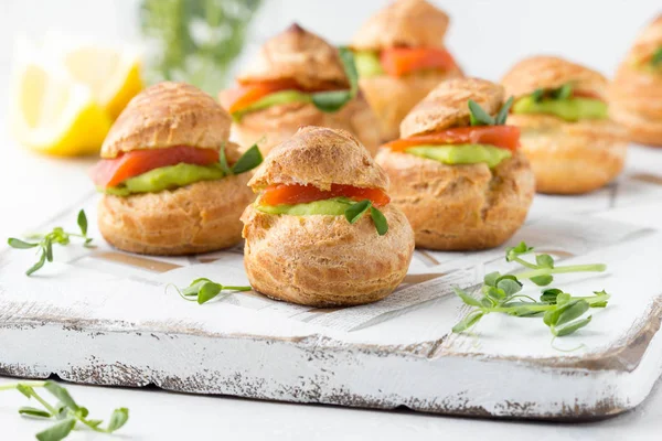 Snack pasteles profiteroles con crema de guisantes verdes y salmón rojo fis —  Fotos de Stock