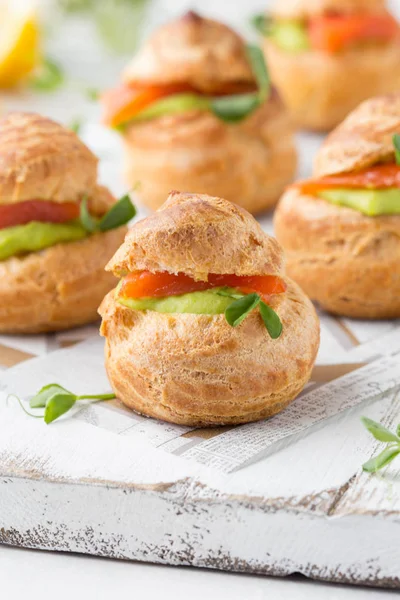 Snack pasteles profiteroles con crema de guisantes verdes y salmón rojo fis — Foto de Stock