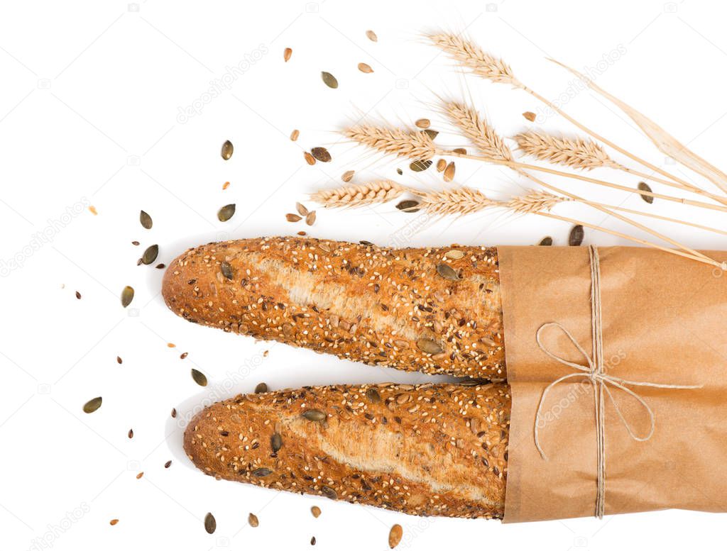   Top view of breads in paper with different seeds ( pumpkin, poppy, flax, sunflower, sesame, millet ) decorated with wheat ears isolated on white background.