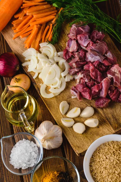 ingredients meat with rice cooking on a wooden table.