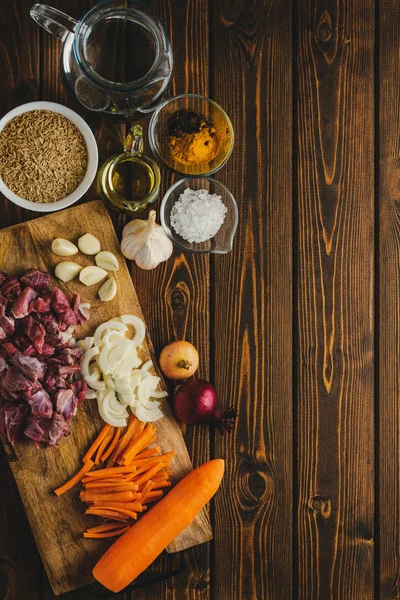 ingredients meat with rice cooking on a wooden table.