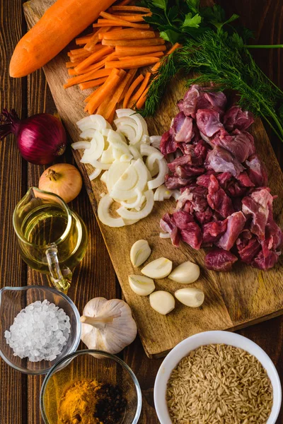 ingredients meat with rice cooking on a wooden table