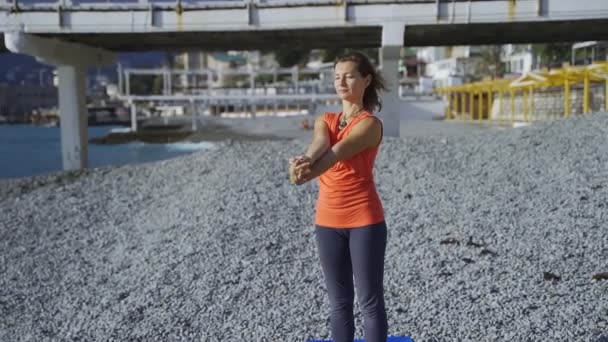 Fille près de la mer faire du yoga sur une plage au lever du soleil — Video