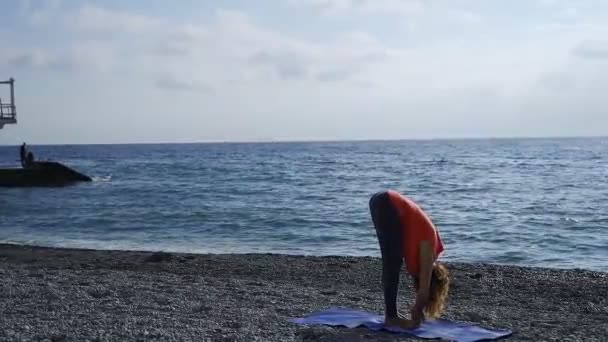 Mädchen am Meer beim Yoga am Strand bei Sonnenaufgang — Stockvideo